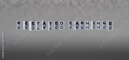 restated earnings word or concept represented by black and white letter cubes on a grey horizon background stretching to infinity
