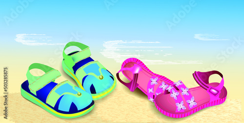 Bright children's sandals on a sandy beach