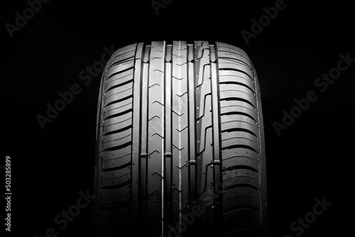 new economical eco-friendly summer tire on a black background, copyspace advertising space.