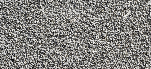 The texture of the surface of a light gray granular concrete wall, cement pattern with cracks on the background with space to copy, panoramic view