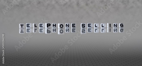 telephone selling word or concept represented by black and white letter cubes on a grey horizon background stretching to infinity