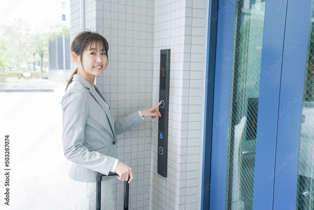 エレベーターを使う若いビジネスウーマン