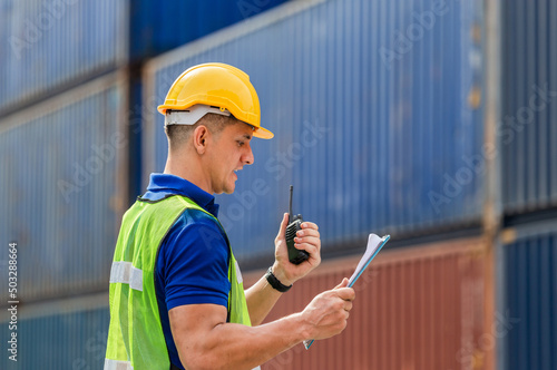 Valokuva Industrial engineer in hard hat containers box background, Dock worker man talks