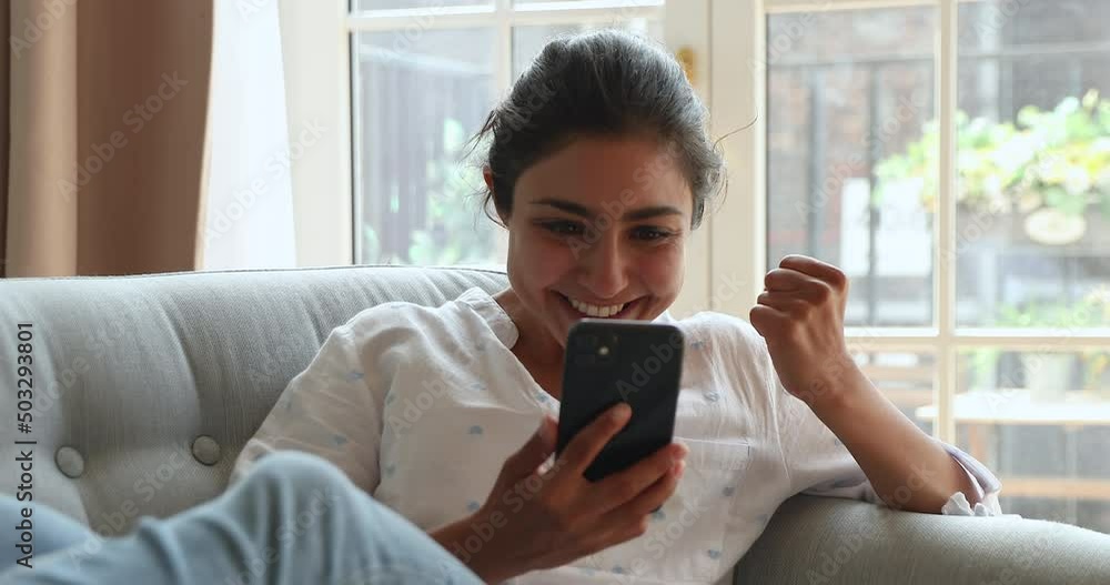 Excited overjoyed Indian female customer look on phone screen scream yes reading unbelievable news about seasonal sale at favorite web store. Euphoric young lady achieve success winning online lottery Excited overjoyed Indian female customer look on phone screen scream yes reading unbelievable news about seasonal sale at favorite web store. Euphoric young lady achieve success winning online lottery