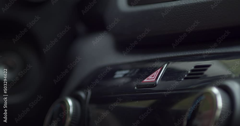 Close-up of person finger hitting car emergency light button on a vehicle's dashboard. Slow-motion shot. 60fps Close-up of person finger hitting car emergency light button on a vehicle's dashboard. Slow-motion shot. 60fps