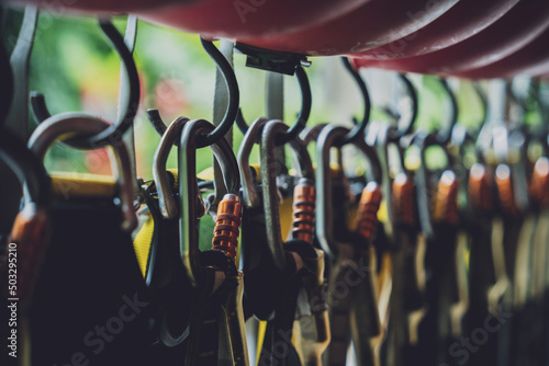 Bild auf Leinwand Rows of climbing safety ropes and carabiners and helmets