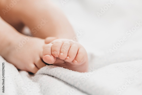 baby legs lie on the bed on a white background. close up. copy space. baby foot care