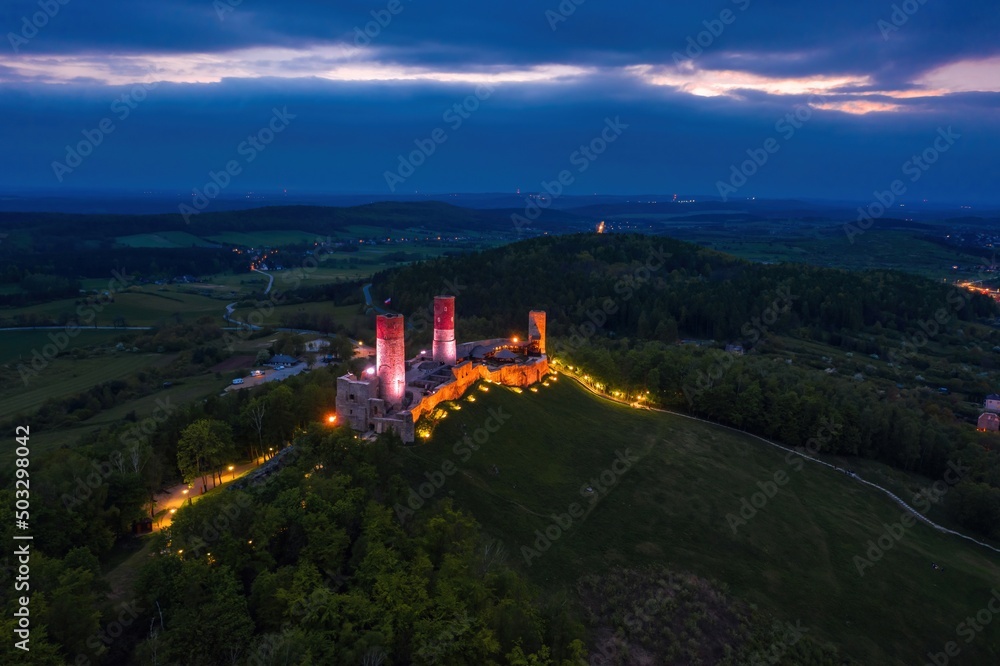 Aerial drone night view over the colorful, illuminated Chęciny Castle (Kielce County, Świętokrzyskie Voivodeship) in Poland