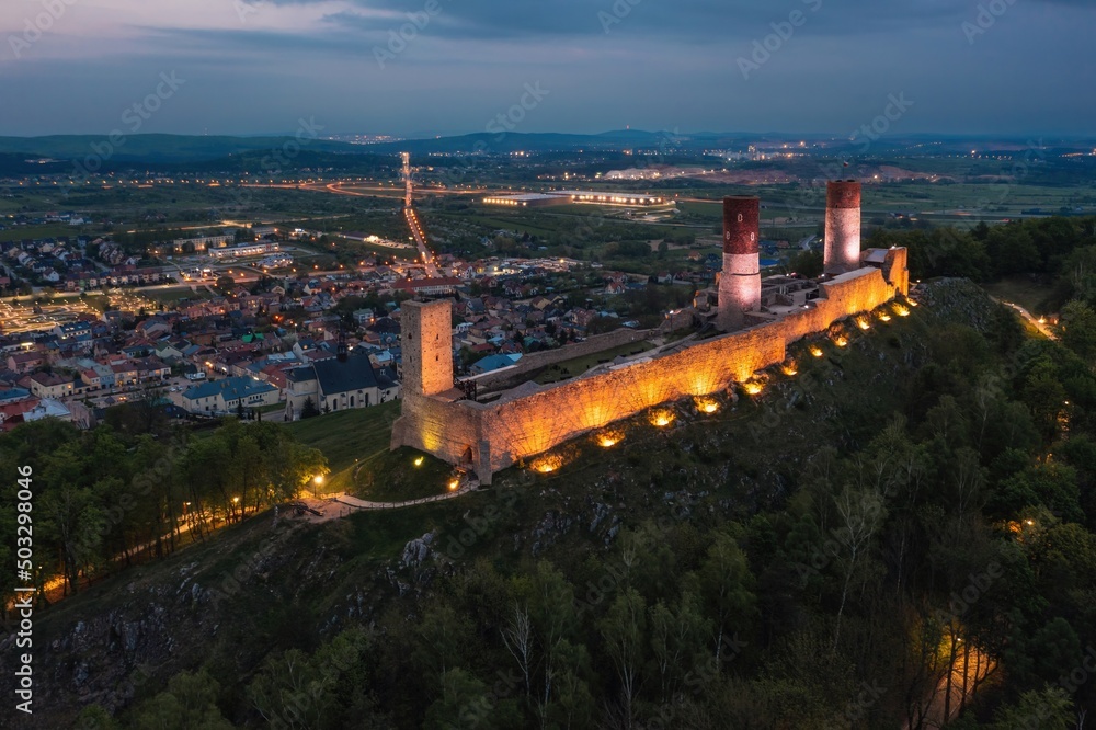 Aerial drone night view over the colorful, illuminated Chęciny Castle (Kielce County, Świętokrzyskie Voivodeship) in Poland 
