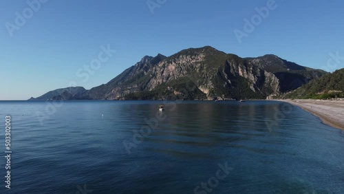 Wallpaper Mural The old man and the sea. Fisherman and a small fishing boat against the backdrop of a beautiful calm sea and mountains. High quality 4k footage Torontodigital.ca