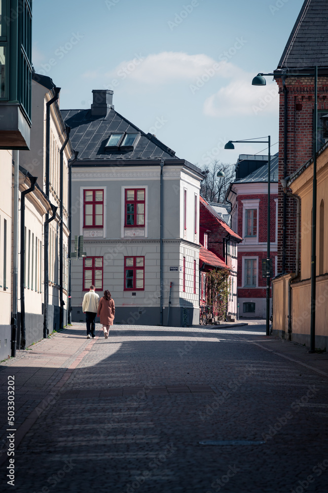 Young student couple walking down the cobblestoned street in Lund old town in Sweden