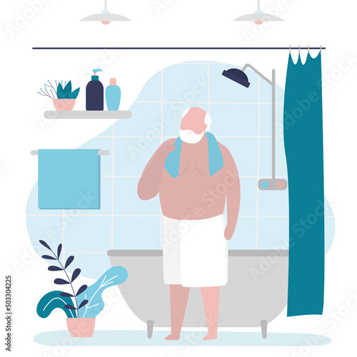 Grandfather finished taking bath. Handsome senior wipes himself off with towel after shower. Old man stands wrapped in towel in bathroom. Personal hygiene and healthcare concept.