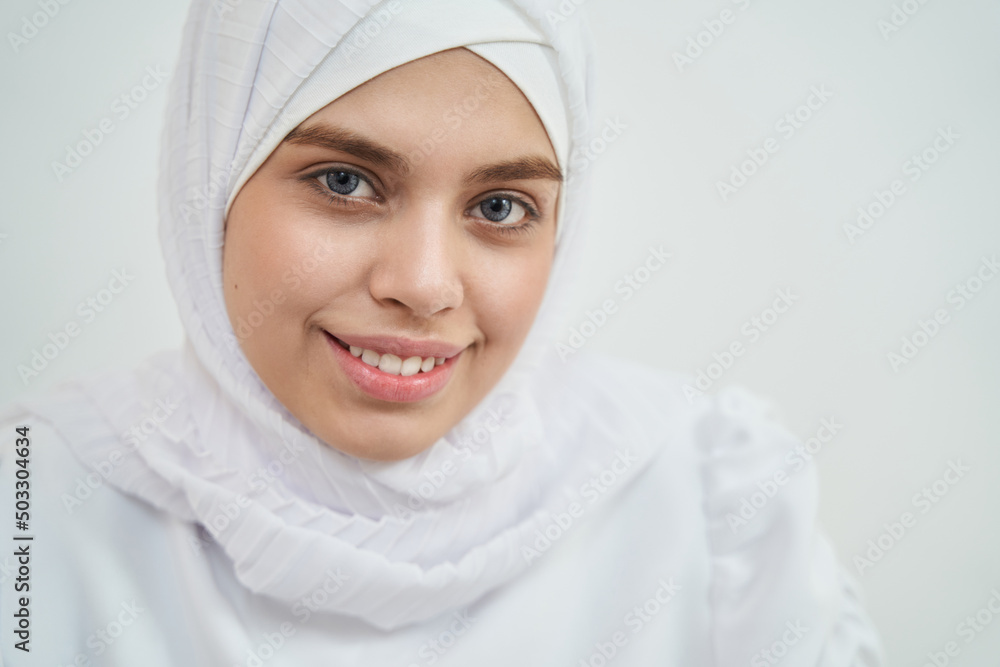 Cheerful Muslim young woman wearing white traditional hijab Cheerful Muslim young woman wearing white traditional hijab