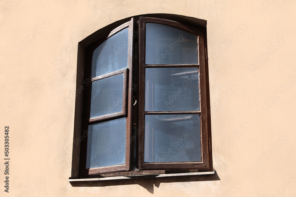 Old arched window in building, view from outdoors