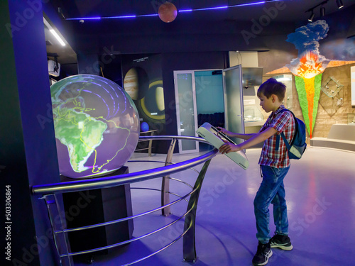 Yong school boy enjoy play and learn with science learning activities at the space and Earth evolution museum on weekends, Novosibirsk - Russia, 6 april 2022
