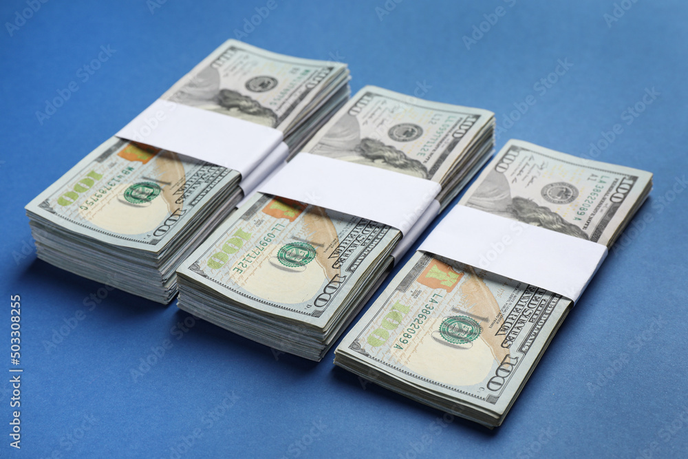 Many dollar banknotes on blue background. American national currency Many dollar banknotes on blue background. American national currency