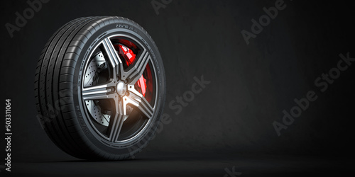 Tableau sur toile Car wheel. Disk with tyre and brakes on black background.