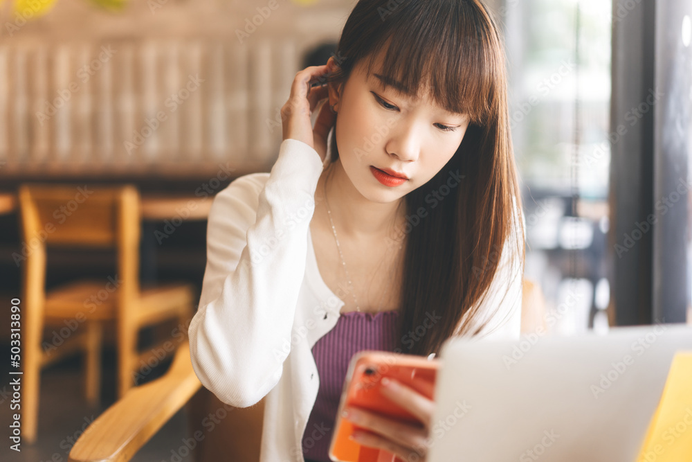 Young adult asian student using mobile phone for online dating at cafe Young adult asian student using mobile phone for online dating at cafe