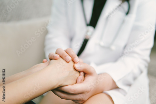 Doctor holding hands to comfort patient, doctor encouraging support and comforting with sympathy. 