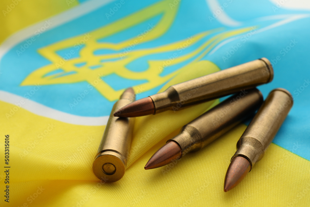 Bullets on national flag of Ukraine, closeup Bullets on national flag of Ukraine, closeup