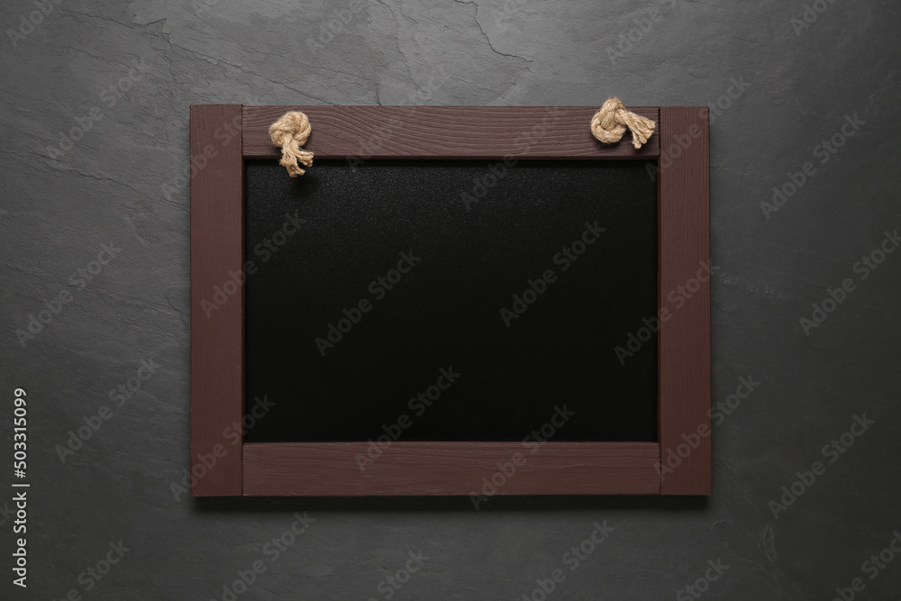 Obraz premium Clean small black chalkboard on dark table, top view