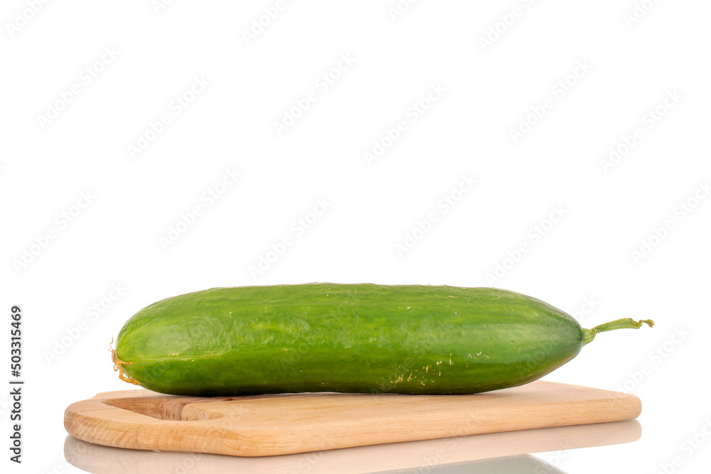 One juicy smooth cucumber on a wooden cutting board, macro isolated on a white background. One juicy smooth cucumber on a wooden cutting board, macro isolated on a white background.