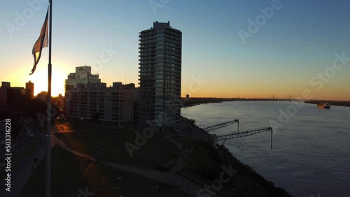 Puerto Norte, Rosario, Argentina: Loading dock in the port of Northern Cordoba used for loading and unloading of goods along the river parana with the view of multi storied buldings during sunset. photo
