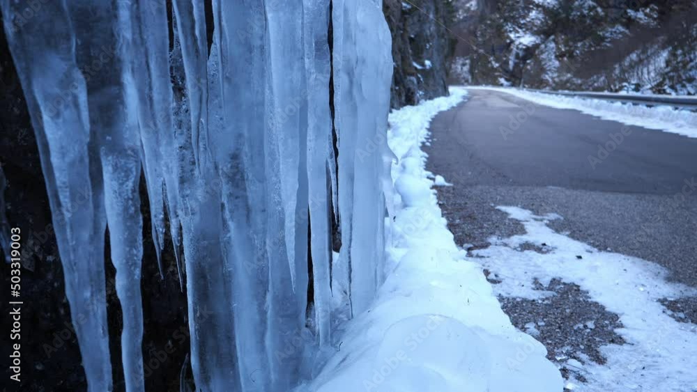 icy road with sharp hanging icicles in winter, difficult road to travel, safety in the car during the winter season in the mountains, ice on roadside icy road with sharp hanging icicles in winter, difficult road to travel, safety in the car during the winter season in the mountains, ice on roadside