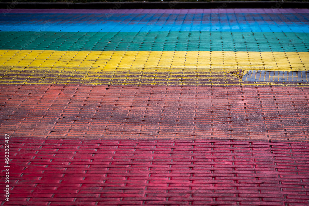 A fragment of the street paved in the colors of the rainbow - obrazy, fototapety, plakaty 