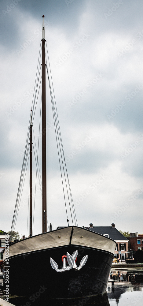 Obraz premium A black barge standing in the marina on the canal