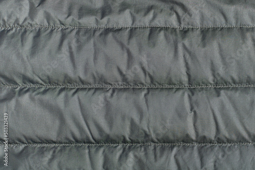 Textile background, green quilted polyamide down jacket texture