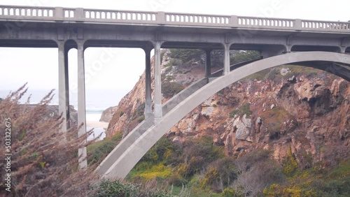 Arch bridge over river creek in canyon, pacific coast highway scenic road, California road trip, Big Sur nature, USA. Cabrillo highway 1, tourist route along ocean. Steep cliffs or rocks under viaduct