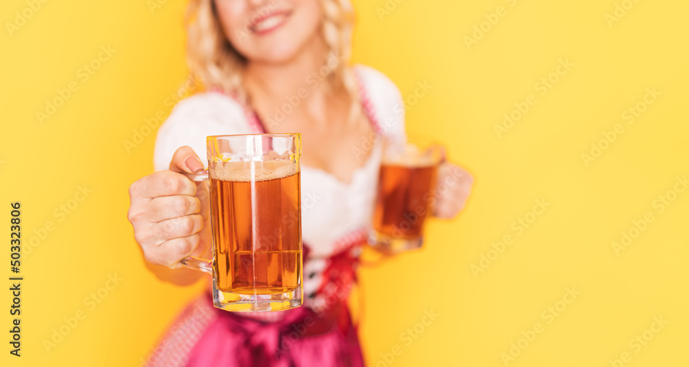 Woman in festive German dress holds out mug of beer forward. Woman in festive German dress holds out mug of beer forward.