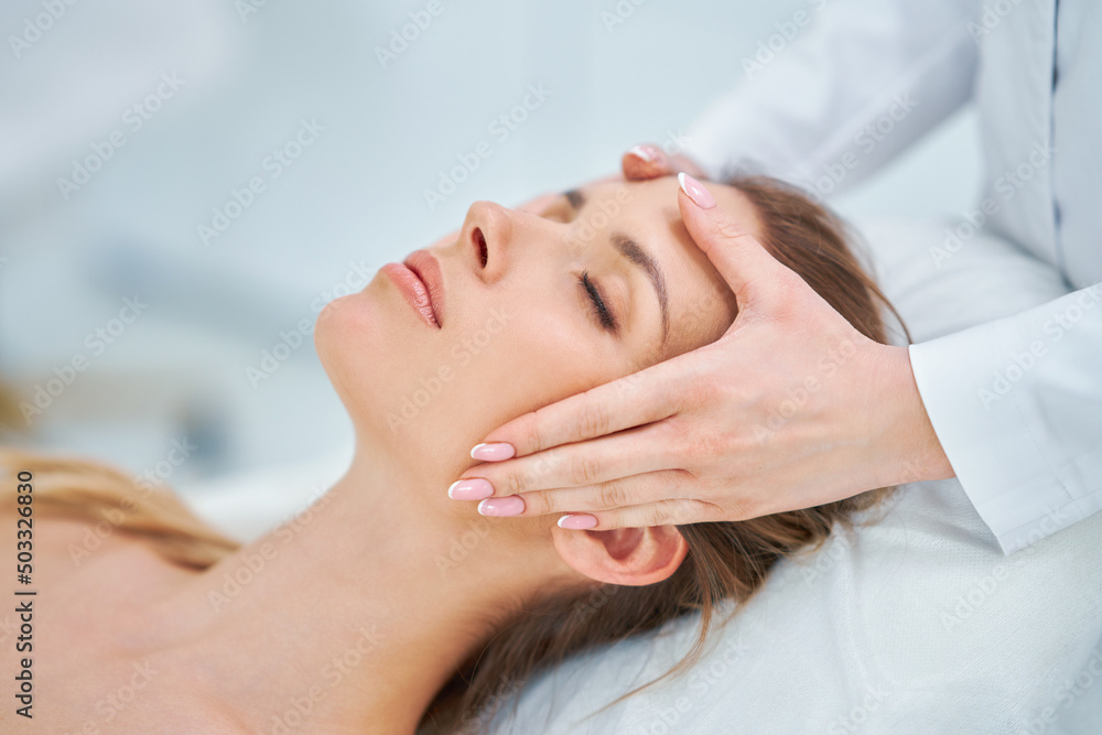 Young nice woman having face massage in spa Young nice woman having face massage in spa