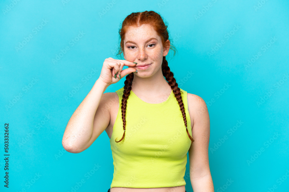 Young reddish woman isolated on blue background showing a sign of silence gesture Young reddish woman isolated on blue background showing a sign of silence gesture