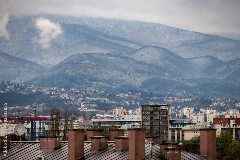 Snow covered slopes of Medvednica mountain in the morning with Zagreb city buildings in the foreground