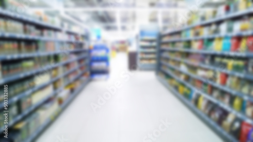 Abstract blur image of supermarket background. Defocused shelves with goods and product. Grocery. Retail industry. Rack. Discount. Inflation and crisis concept. Aisle. Shopping mall. Big company store