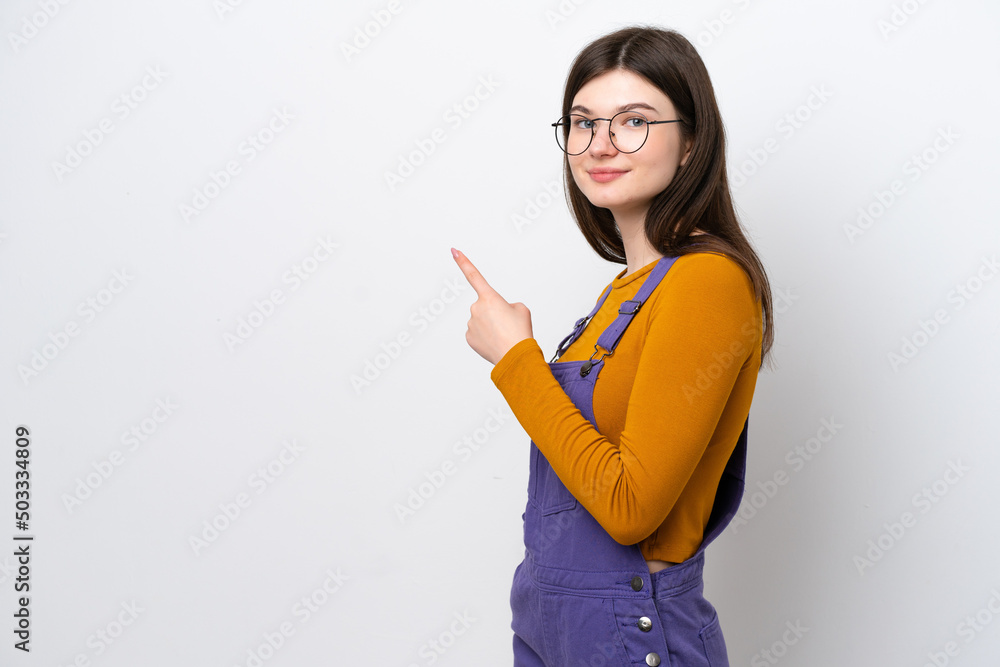 Young Russian woman isolated on blue background pointing finger to the side Young Russian woman isolated on blue background pointing finger to the side