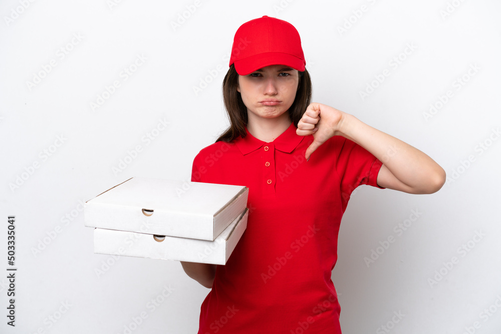Young Russian pizza delivery picking up pizza boxes isolated on white background showing thumb down with negative expression Young Russian pizza delivery picking up pizza boxes isolated on white background showing thumb down with negative expression