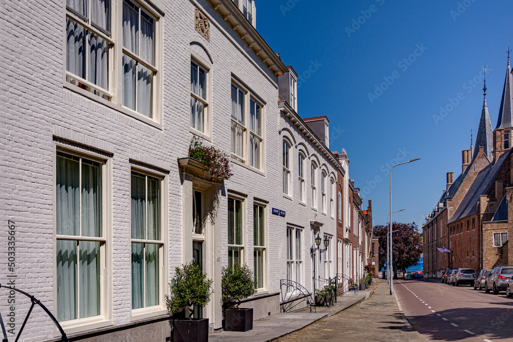 Beautiful perspective line of an old facade houses on a quiet empty street in a bright sunny summer day