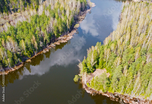 Top view from the quadrocopter of the river and the winter green forest