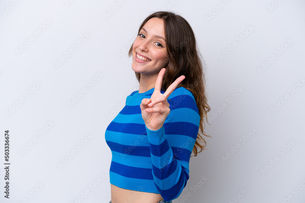 Young caucasian woman isolated on white background smiling and showing victory sign