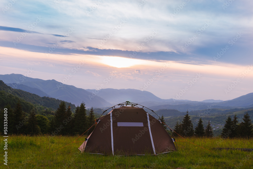 Brown tent. Quick installation system. Summer day. Mountains and forest, travel and tourism concept. Camping. Copy space.