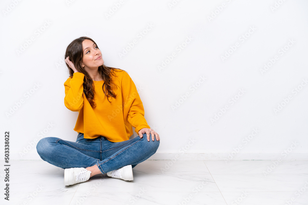 Young caucasian woman sitting on the floor isolated on white wall thinking an idea Young caucasian woman sitting on the floor isolated on white wall thinking an idea