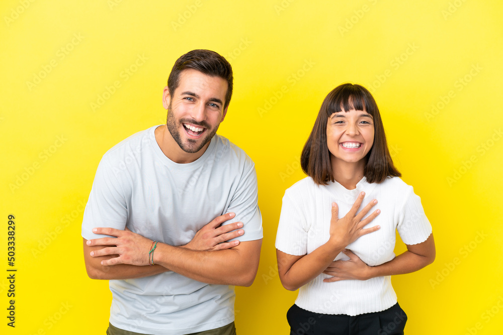 Young couple isolated on yellow background keeping the arms crossed while smiling Young couple isolated on yellow background keeping the arms crossed while smiling