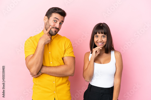 Young couple isolated on pink background smiling with a sweet expression