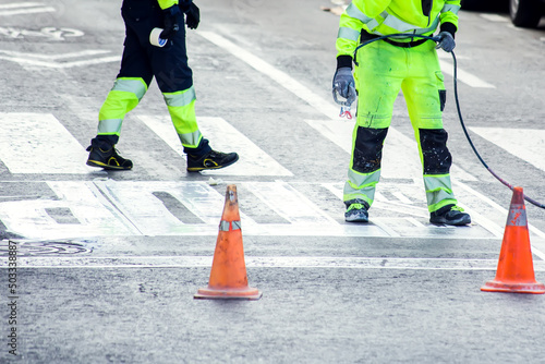 Traffic line painting. Workers painting white street lines on pedestrian crossing