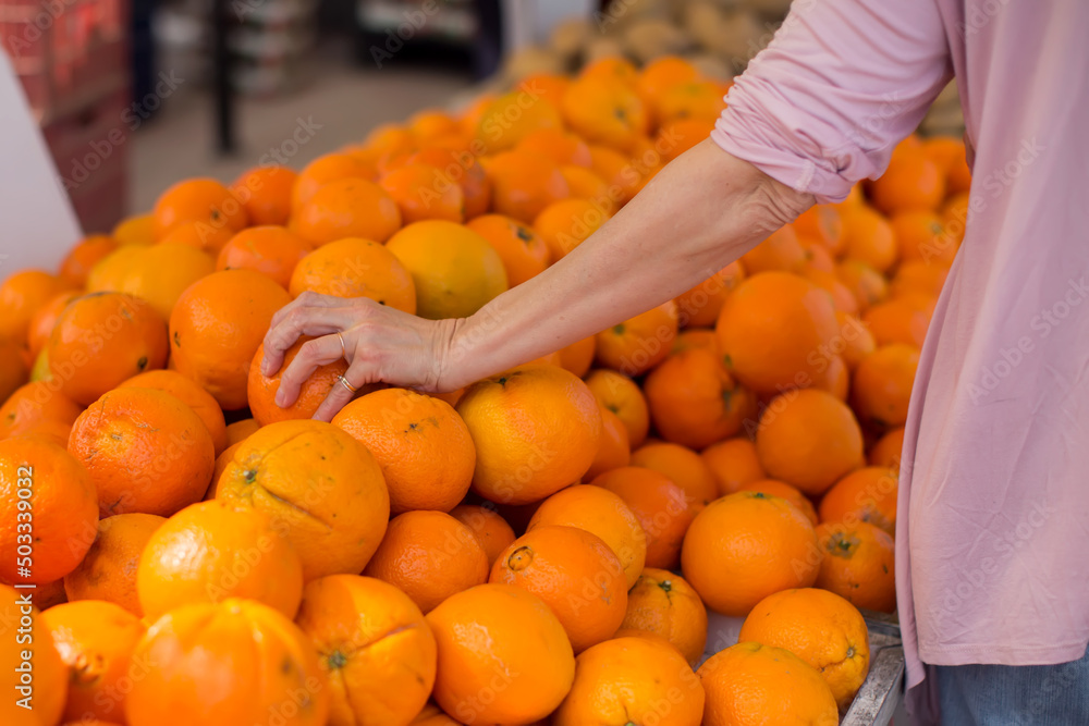 Customer buying fresh oranges at food market