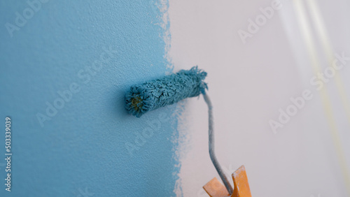 Canvastavla Decorator hand painting wall with roller closeup