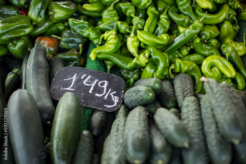 Cucumbers with price and green pepper at the lockal market photo